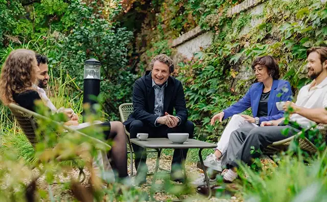 Gereon Friederes unterhält sich in lockerer Atmosphäre mit Karin Graf, Philipp Zelenka, Sophie Buchta und Youssef Kawmi im Garten des marketmind Büros.