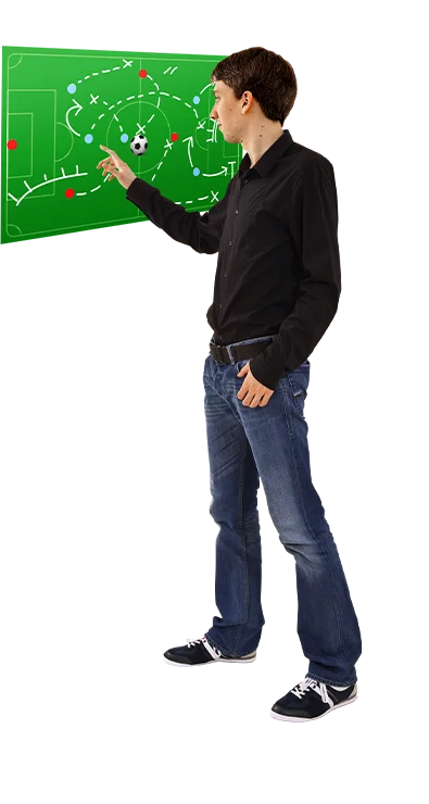 Dipl.-Ing. Thomas Schuster erklärt mit ausgestrecktem Arm eine komplexe Fussballtaktik auf einer Tafel - strategisch, analytisch und mit Leidenschaft für den Sport.