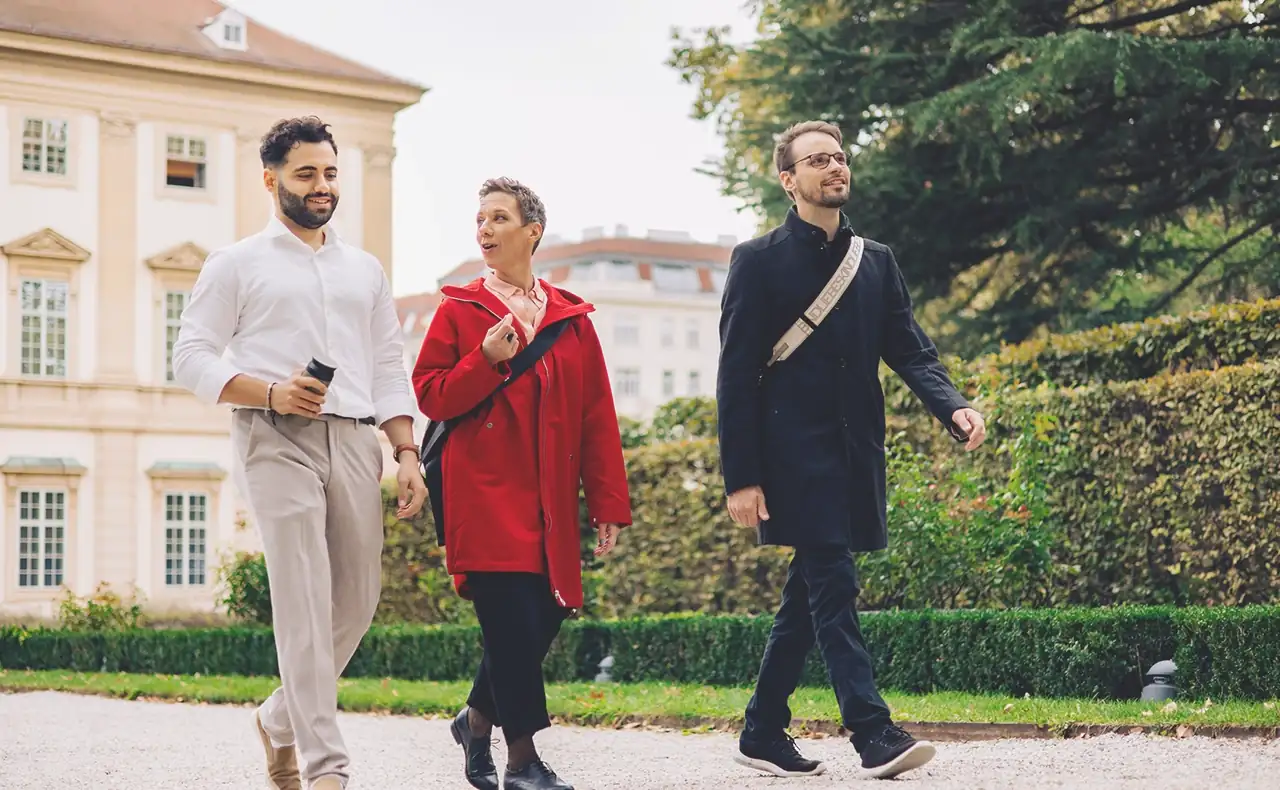 Daniel Winzer, Dagmar Jiresch, and Youssef Kawmi taking a walk together through the park of the Liechtenstein palace, located in the immediate vicinity of the marketmind office.