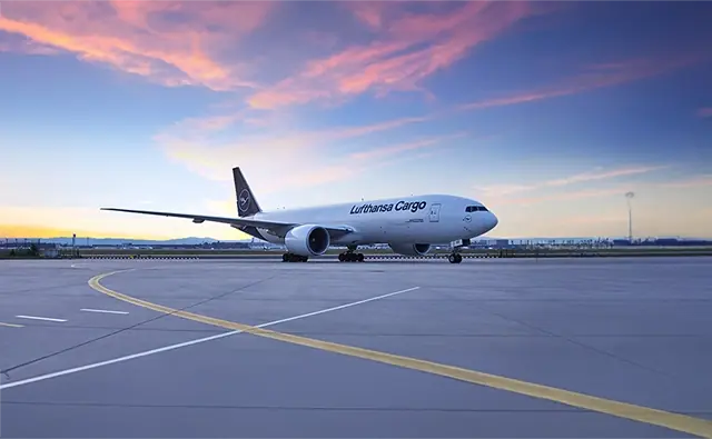 Lufthansa Cargo freight aircraft on a runway at sunset. Image represents global logistics solutions and efficient air cargo logistics.