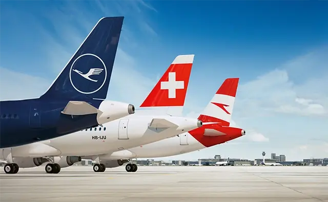 Aircraft of various airlines of the Lufthansa Group with visible tail fins on the tarmac.
