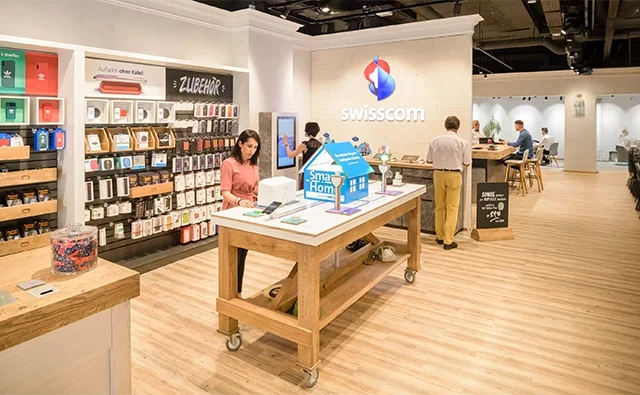 Modern Swisscom customer service center with minimalist interior and brand logo. Image represents digitalization, consulting expertise, and customer proximity.