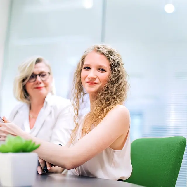 Sophie Buchta sits in a meeting room at the markemtind office, where Britta Veser assists her with her work.