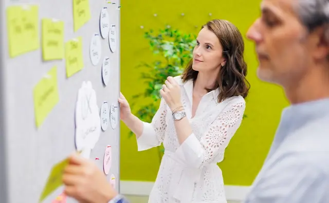 Birgit Schrenk and Erik Stadler are working on the flipchart using a creativity method.