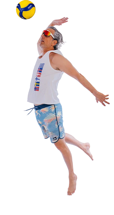 Erik Stadler jumps dynamically into the air and hits a volleyball over the net - athletic, energetic, and full of summer vibes.