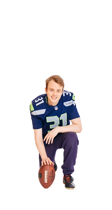 Jan-Michael Bussmann kneels in American football outfit with a football in hand - athletic, determined, and ready for the next play.