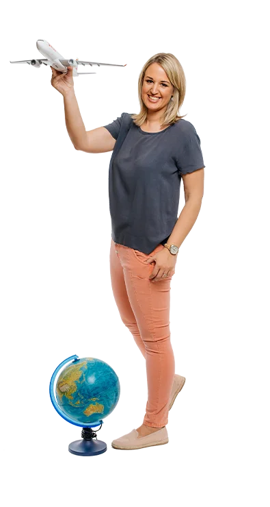 Katrin Groiss-Schuster holds a model airplane in one hand, with a globe at her feet - full of wanderlust and travel desire.