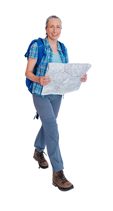 Klara Kögerler hikes forward smiling with backpack and large map in hands - nature-connected, goal-oriented, and full of explorer joy.