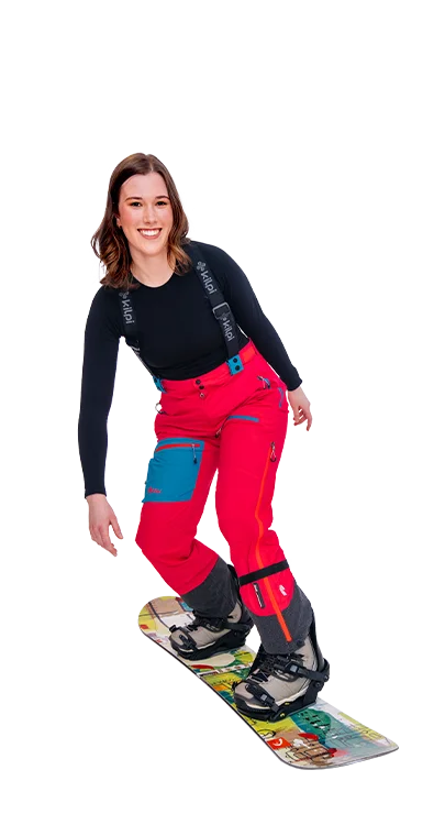Lena Hammer rides on a snowboard in bright red ski clothing, laughs at the camera - full of momentum and fun in the snow.