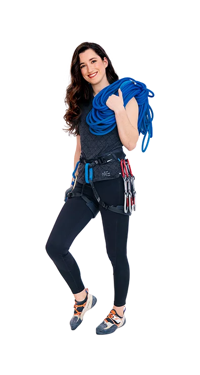 Lisa Videnova wears climbing gear with rope over the shoulder and carabiners on the harness - brave, athletic, and ready for the next adventure in the vertical.