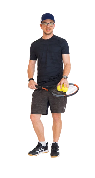 Matthias Kausel stands in sports outfit with tennis racket in hand and two tennis balls - athletic, focused, and ready for the next match.