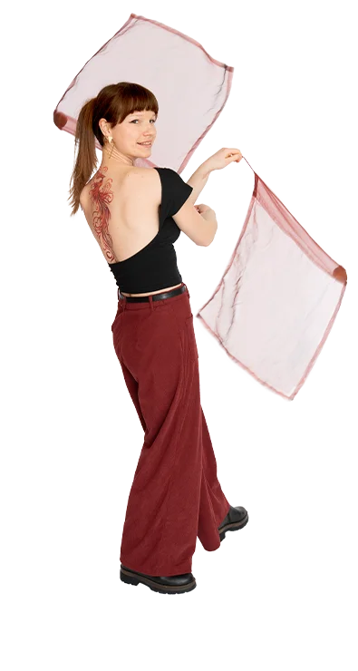 Luca Zsofia Trapp turns in motion with two light scarves in hands, a striking tattoo visible on the back.